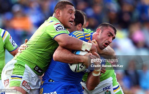 Tim Mannah of the Eels is tackled high by Josh Papalii of the Raiders during the round 26 NRL match between the Parramatta Eels and the Canberra...