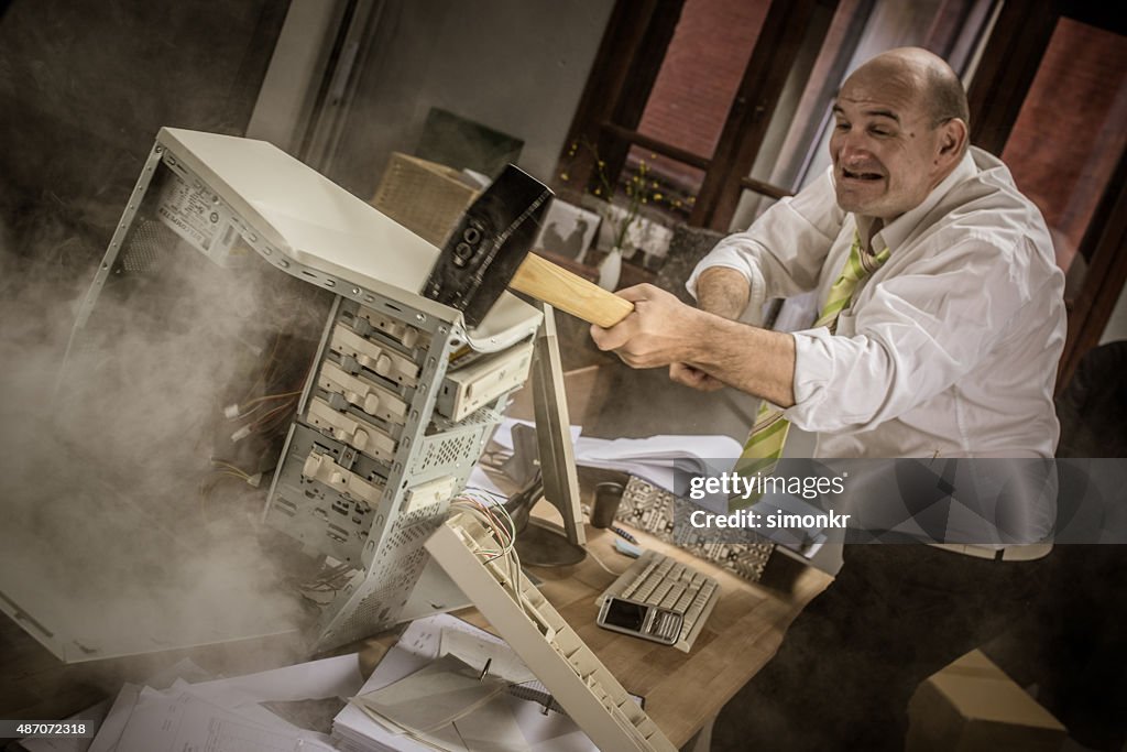 Businessman hitting hammer on CPU