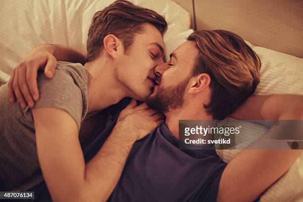 junge lesbische paar im schlafzimmer. - two men in bed cuddling stock-fotos und bilder