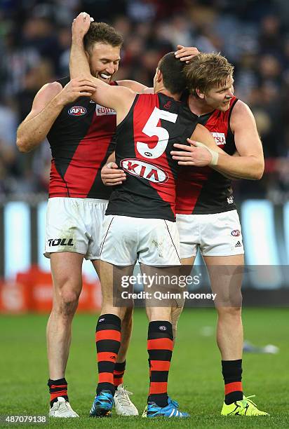 Cale Hooker, Brent Stanton and Michael Hurley of the Bombers celebrate winning the round 23 AFL match between the Collingwood Magpies and the...