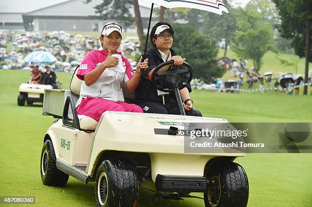 Misuzu Narita of Japan sits in golf carts as she is driven to the 18th tee for a playoff during the final round of the Golf 5 Ladies Tournament 2015...