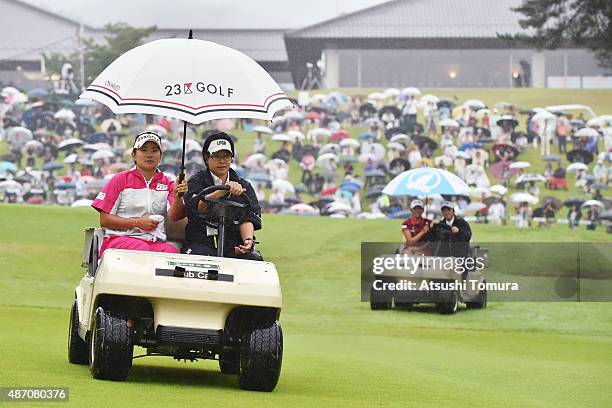 Misuzu Narita of Japan and Bo-Mee Lee of South Korea sit in golf carts as they are driven to the 18th tee for a playoff during the final round of the...