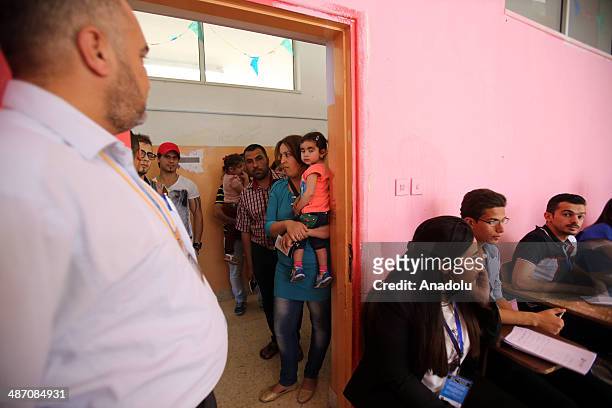 Iraqis living in Jordan capital Amman, wait in queue to cast their ballots in the Iraqi parliamentary elections at the polling station in Amman,...