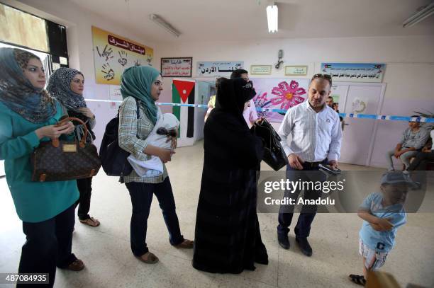 Iraqis living in Jordan capital Amman, wait in queue to cast their ballots in the Iraqi parliamentary elections at the polling station in Amman,...