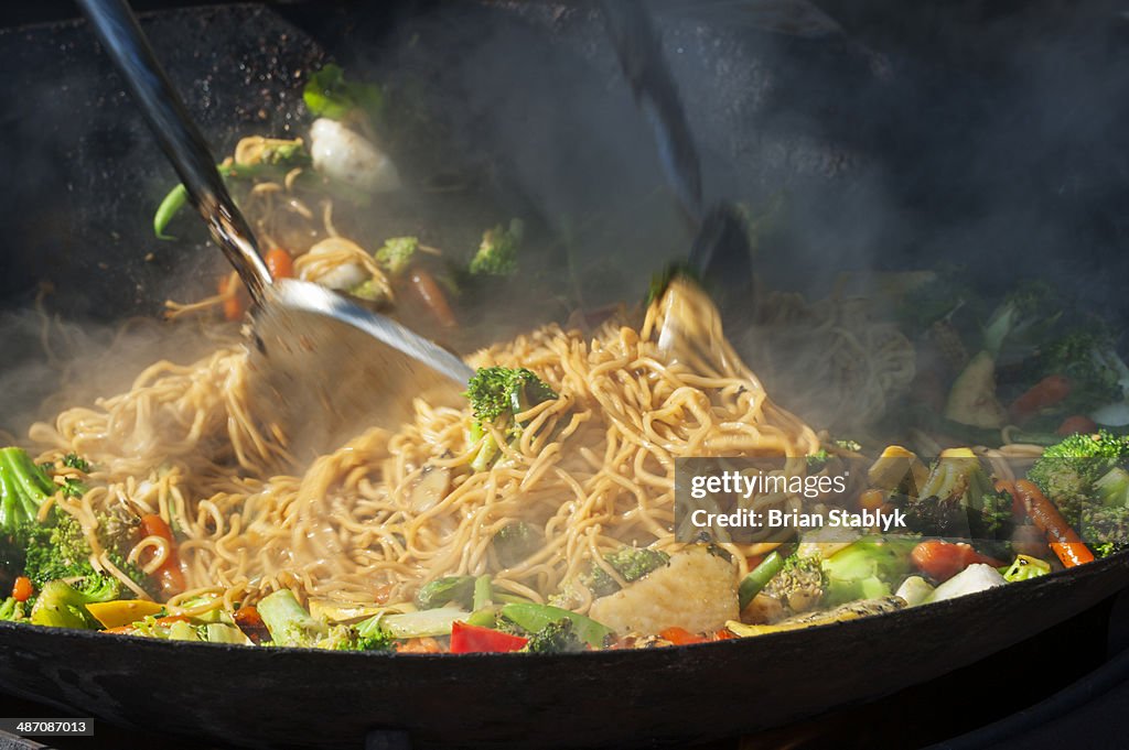 Sauteing chow mein in a wok