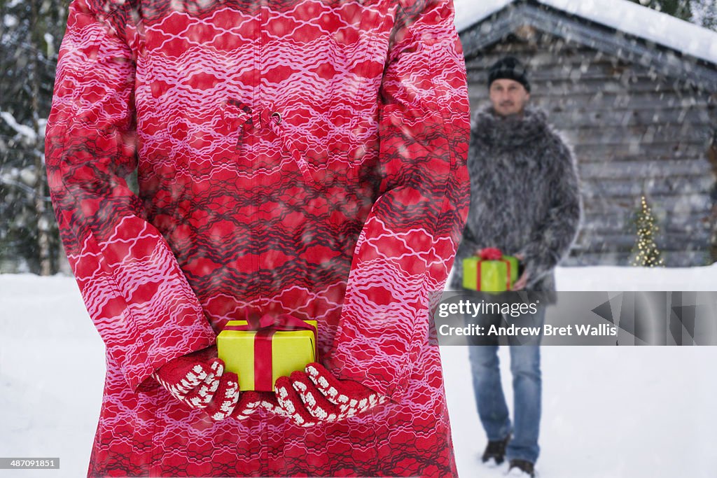 Woman and man outdoors exchange gifts