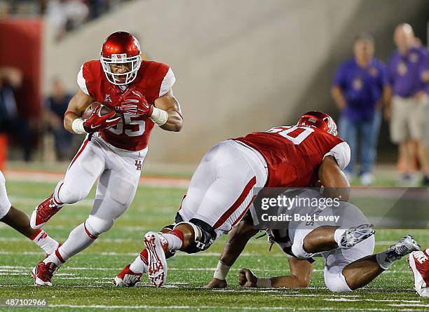 Kenneth Farrow of the Houston Cougars receives a block from Alex Cooper of the Houston Cougars as he rushes up the field on September 5, 2015 in...