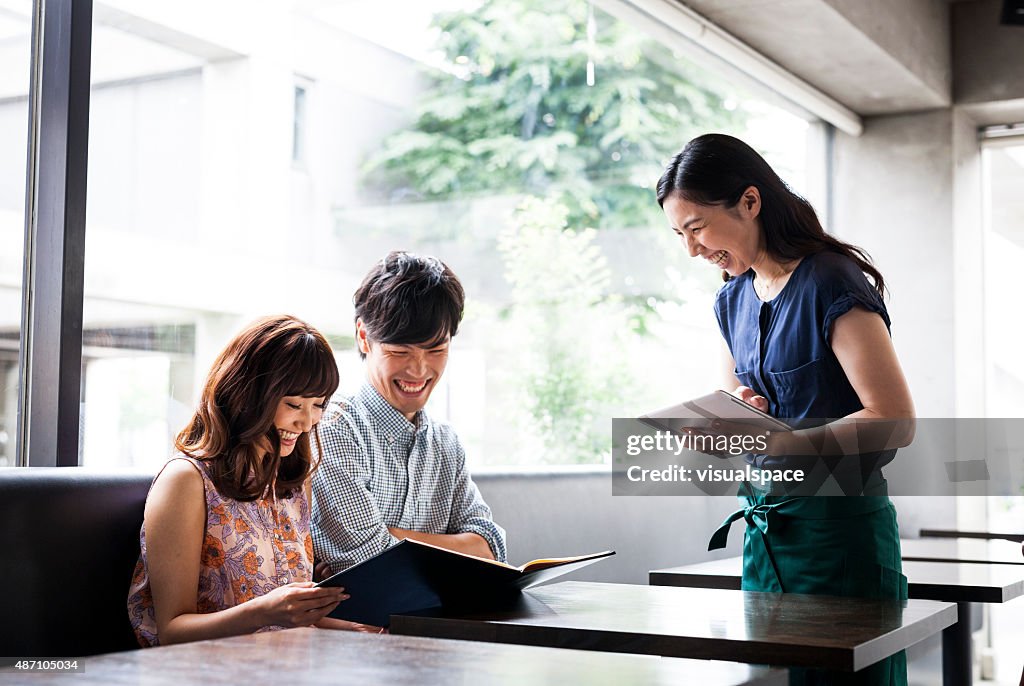 Asian couple ordering food in cafeteria