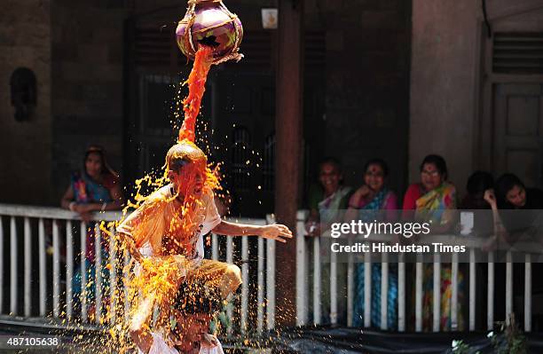 Youth tumble in an attempt to form a human pyramid to break the "Dahi Handi," an earthen pot filled with curd hanging above, an integral part of...