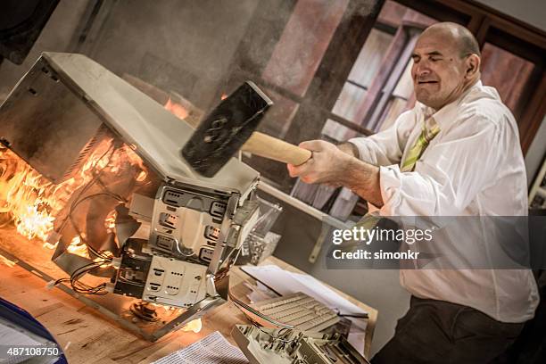 uomo d'affari premendo martello a bruciare processore - furious foto e immagini stock