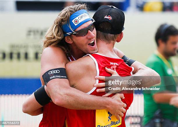 Aleksandrs Samoilovs and Janis Smedins of Latvia celebrate their victory after winning the gold medal match against Germany at Copacabana beach...