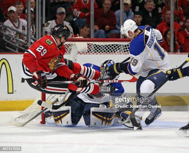 Brian Bickell of the Chicago Blackhawks goes airbourne after taking a shot against Ryan Miller and Jay Bouwmeester of the St. Louis Blues in Game Six...