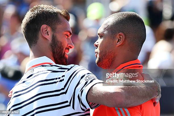 Jo-Wilfried Tsonga of France embraces Benoit Paire of France at the net after defeating him during their Men's Singles Fourth Round match on Day...