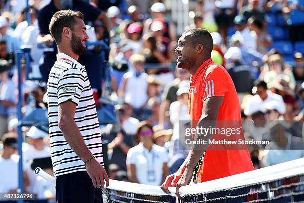 Jo-Wilfried Tsonga of France greets Benoit Paire of France at the net after defeating him during their Men's Singles Fourth Round match on Day Seven...