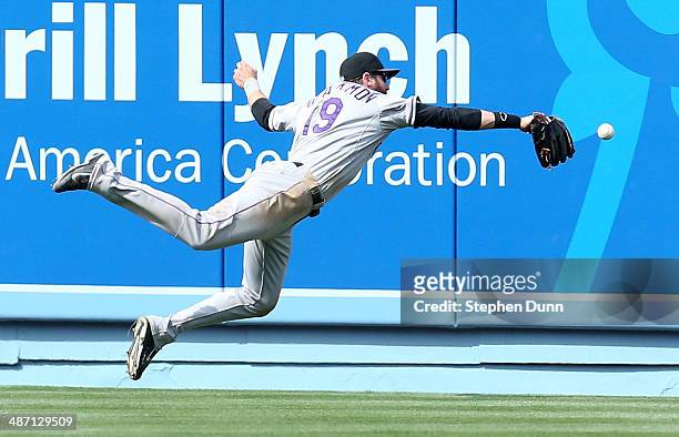 Center fielder Charlie Blackmon of the Colorado Rockies dives but can't catch a double hit by Matt Kemp of the Los Angeles Dodgers in the eighth...