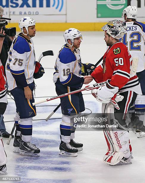 Corey Crawford of the Chicago Blackhawks shakes hands with Derek Roy and Ryan Reeves of the St. Louis Blues after Game Six of the First Round of the...