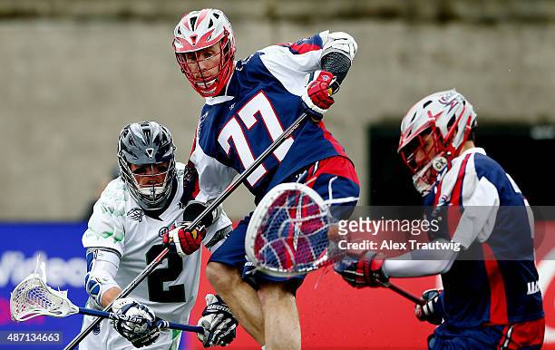 Brendan Mundorf of the Chesapeake Bayhawks goes to the goal as Kyle Sweeney of the Boston Cannons defends and Jordan Burke makes a save during a game...