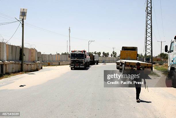 Trucks loaded with food supplies cross into the Palestinian city of Rafah through the Kerem Shalom crossing between Israel and the southern Gaza...