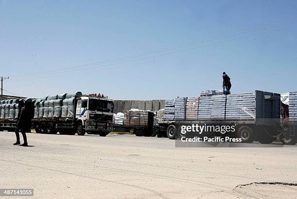 Trucks loaded with food supplies cross into the Palestinian city of Rafah through the Kerem Shalom crossing between Israel and the southern Gaza...