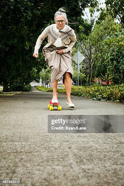 determined grandma on skateboard - young at heart stock pictures, royalty-free photos & images