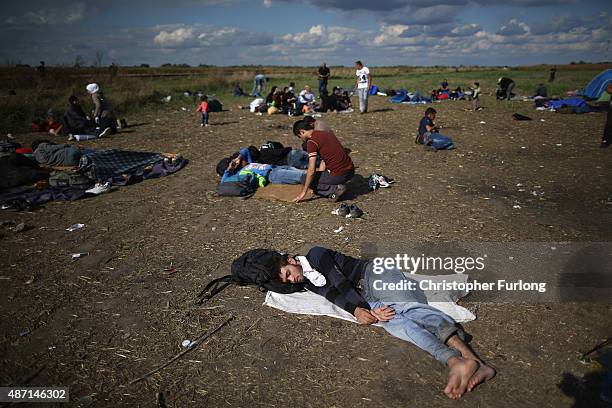 Exhausted migrants rest in a holding area after crossing the border from Serbia into Hungary along the railway tracks close to the village of Roszke...