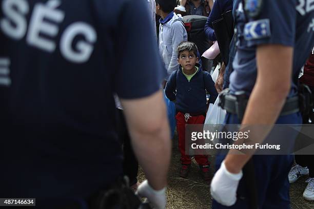Migrants are greeted by Hungarian police after crossing the border from Serbia into Hungary along the railway tracks close to the village of Roszke...