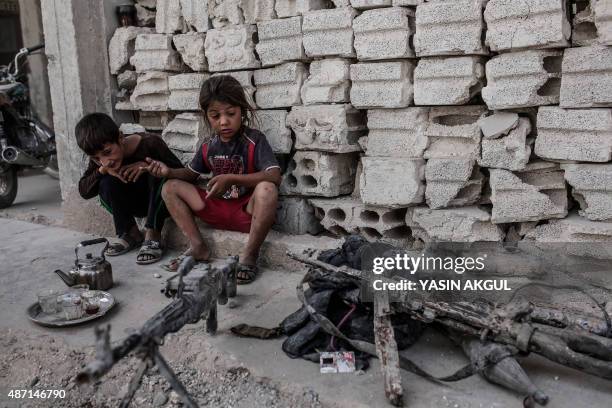 Children look at seized weapons from IS on September 6 ,2015 in Kobane, northern Syria. Several Turkish soldiers were killed on September 6, 2015 in...