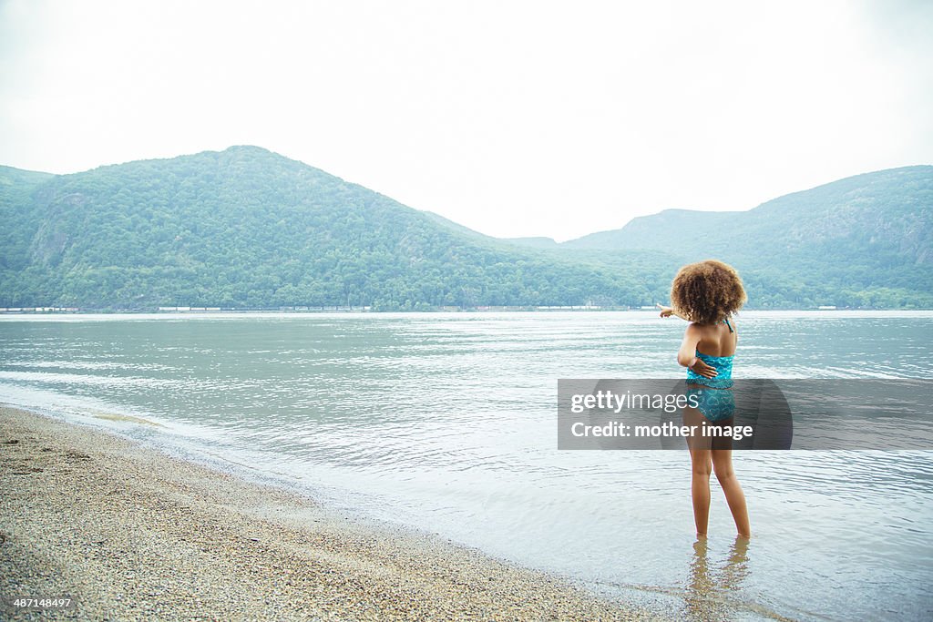 Young girl wading in lake