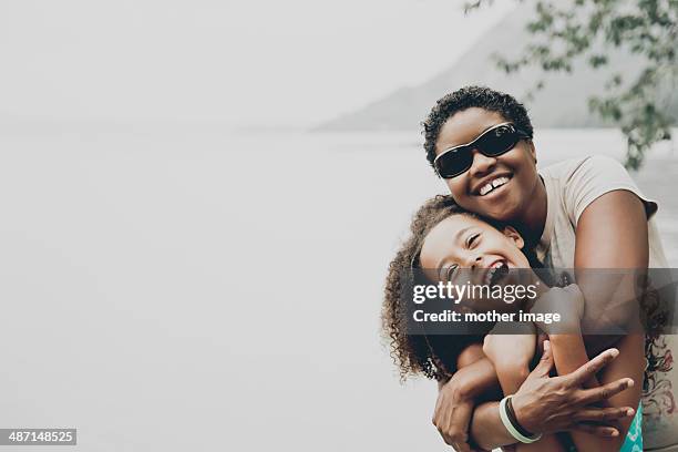 mother and daughter laughing and hugging - agua estancada fotografías e imágenes de stock
