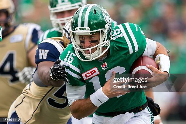 Brett Smith of the Saskatchewan Roughriders scrambles with the ball in first half action of the game between the Winnipeg Blue Bombers and...