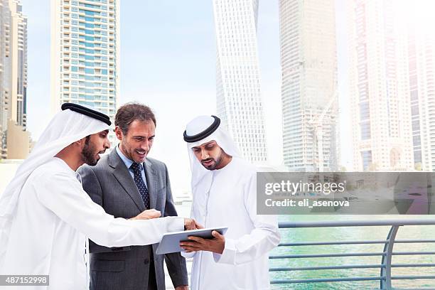 businessmen using tablet in dubai marina. - dubai business stock pictures, royalty-free photos & images