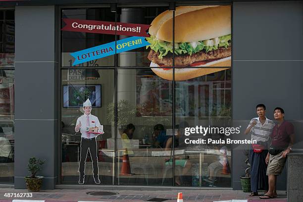 Burmese walk by the new Lotteria restaurant which is a large chain of fast-food restaurants April 19, 2014 in Yangon, Myanmar. The Lotteria chain is...