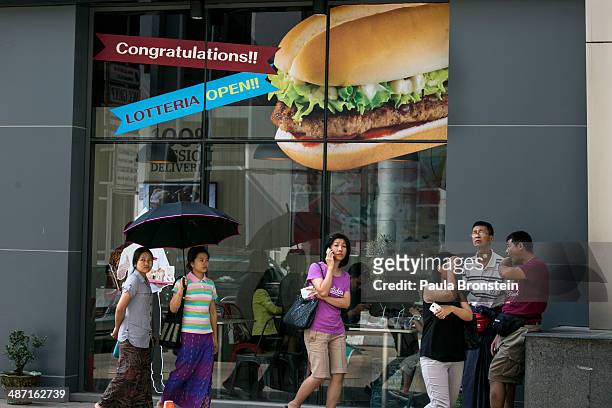 Burmese walk by the new Lotteria restaurant, a large chain of fast-food restaurants April 19, 2014 in Yangon, Myanmar. The Lotteria chain has outlets...