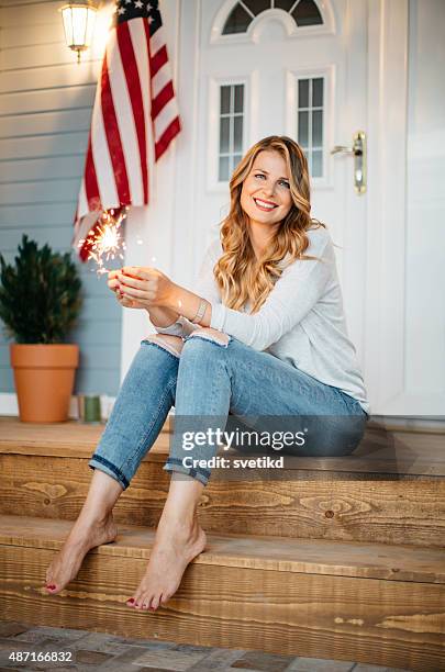 woman in front of a house. - american flag fireworks stock pictures, royalty-free photos & images