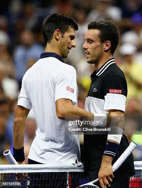 Novak Djokovic of Serbia shakes hands at the net after his four set victory against Roberto Bautista Agut of Spain in their mens singles fourth round...