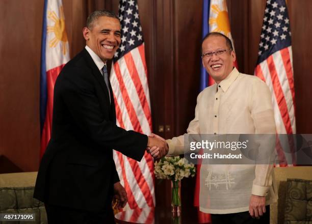 In this handout provided by Malacanang Photo Bureau', US president Barack Obama shakes hands with Philippine President Benigno Aquino at the...