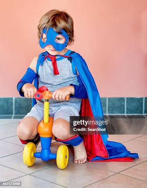 little superhero riding a 4 wheels toy vehicle - baby superhero stock pictures, royalty-free photos & images