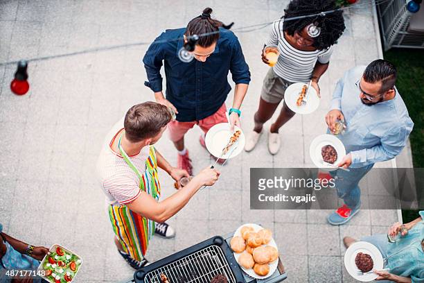 happy young people eating at barbecue party. - grill directly above stock pictures, royalty-free photos & images