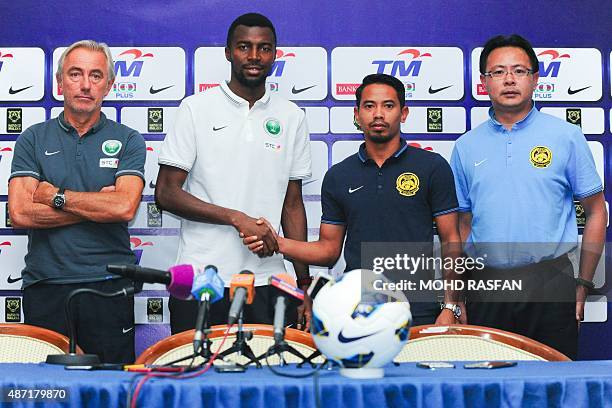 Malaysia's team captain Safiq Rahim shakes hands with Saudi Arabia's team captain Osama Hawsawi as Malaysia's football interim coach Ong Kim Swee and...