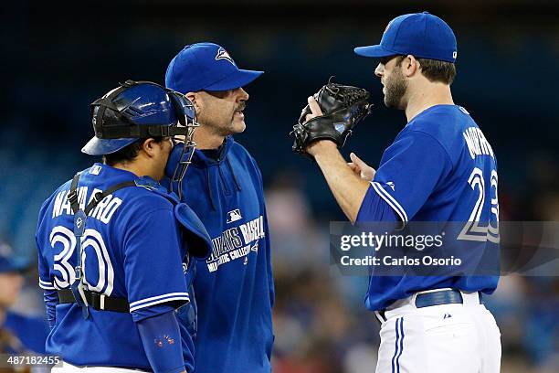 Pitching coach Pete Walker visits the mound with Dioner Navarro to speak with pitcher Brandon Morrow in the 2nd inning during the MLB game between...