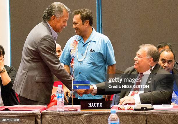 Cook Islands Prime Minister Henry Puna shakes hands with Nauru's President Baron Waqa as Palau's President Tommy Remengesau looks on during the...