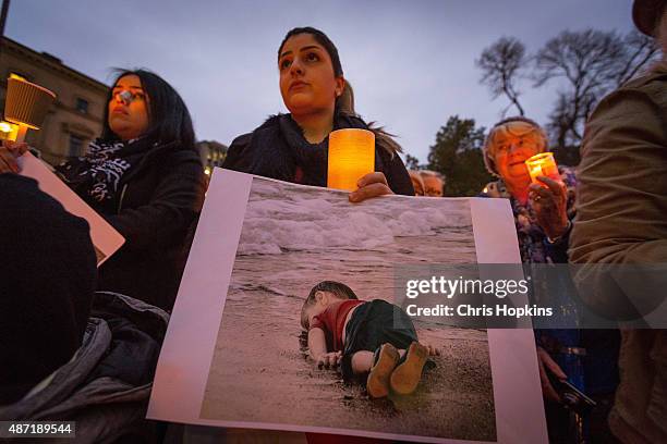 Woman holds a picture during the quiet vigil in rememberence of Aylan Kurdi on September 7, 2015 in Melbourne, Australia. Thousands of people around...