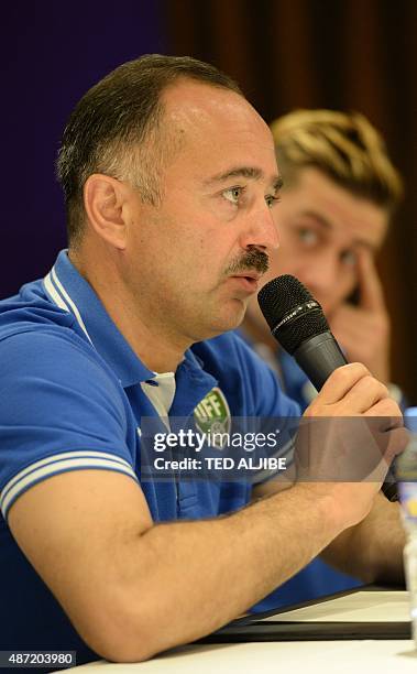 Samvel Babayan head coach of Uzbekistan's football team speaks as player Djeparov Server listens during a pre-match press conference in Manila on...