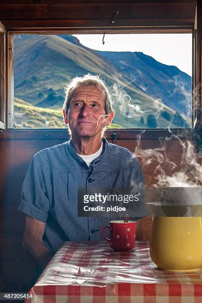 farmer trinkt kaffee im farmhouse, schweiz - alpen berghütte stock-fotos und bilder