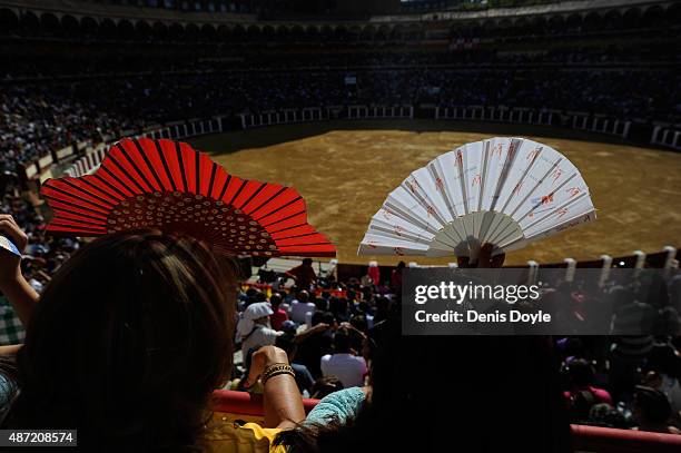 Spectators shield themselves from the sun's rays with fans at the start of the Liga de Corte Puro finals at the Plaza de Toros on September 6, 2015...