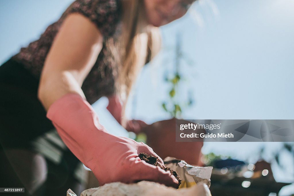 Woman planting on balcony.