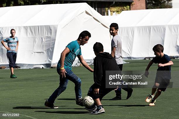 Migrants play soccer at a short-term housing facility for arriving migrants and refugees in Spandau district on September 7, 2015 in Berlin, Germany....