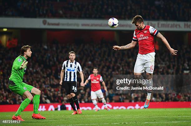 Olivier Giroud of Arsenal heads the ball past goalkeeper Tim Krul of Newcastle United to score their third goal during the Barclays Premier League...