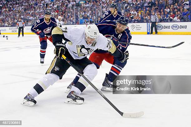 Evgeni Malkin of the Pittsburgh Penguins attempts to skate the puck past Jack Johnson of the Columbus Blue Jackets during the first period of Game...