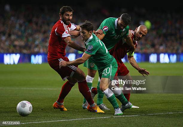 Ucha Lobjanidze of Georgia, Wes Hoolahan of the Republic of Ireland, Jonathan Walters of the Republic of Ireland and Jaba Kankava of Georgia battle...